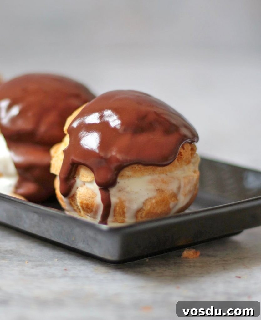 Classic French Profiteroles with Rich Chocolate Sauce 8 Close-up on a Profiteroles over a black plate