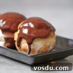 Classic French Profiteroles with Rich Chocolate Sauce 9 Zoom on one choux covered with warm chocolate sauce