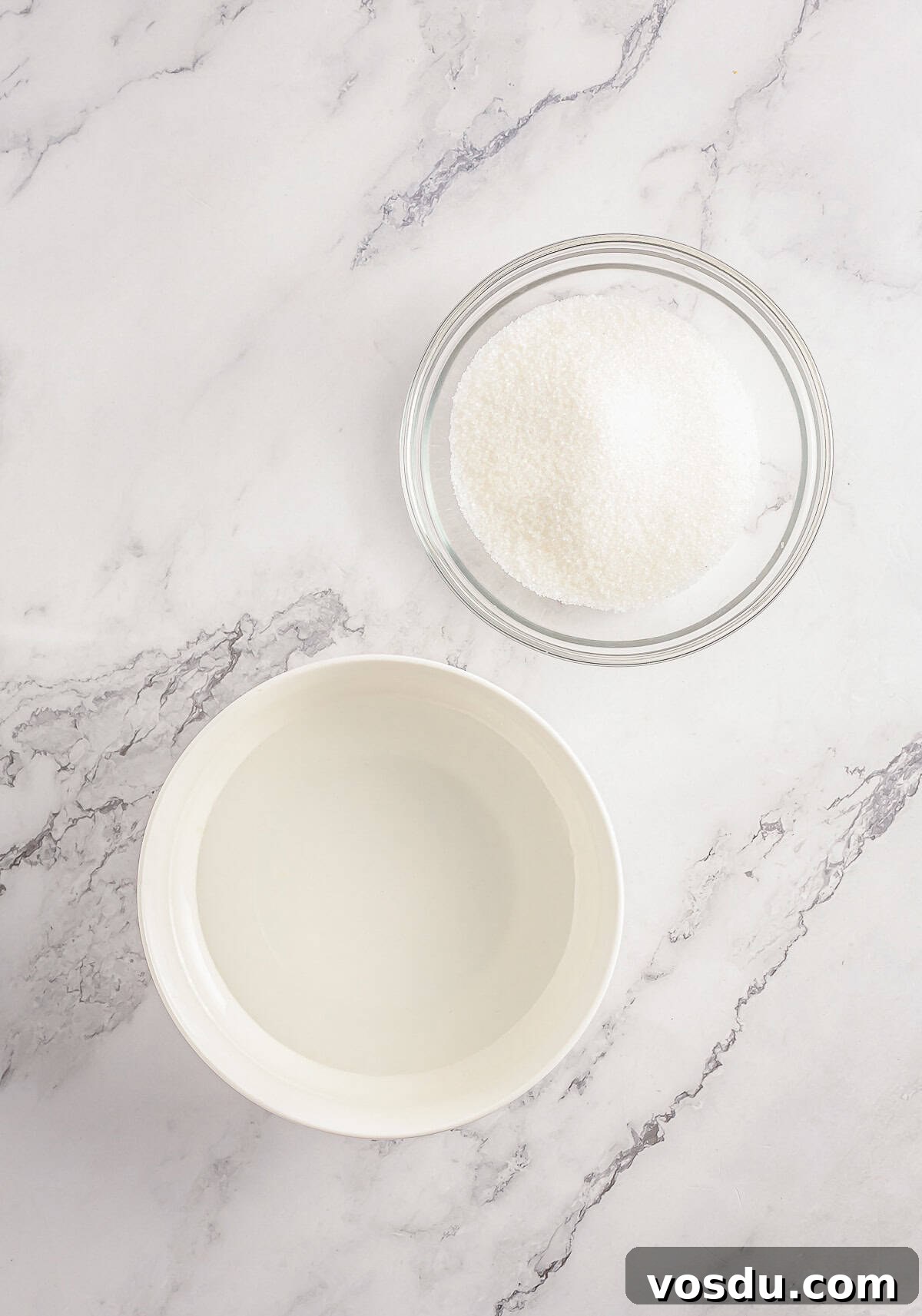 Ingredients for simple syrup on a grey marble tabletop