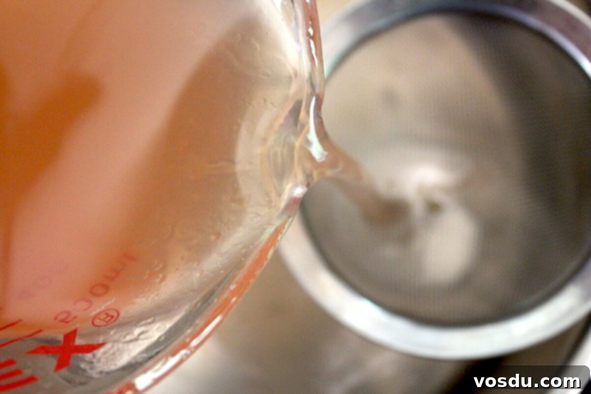 Homemade Peach Jelly Canning Recipe: Step-by-Step Guide 6 Filtering extracted peach juice through cheesecloth for jelly