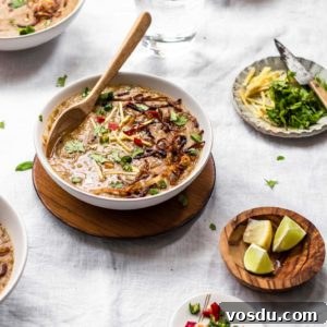 Instant Pot Pakistani-style Haleem made with beef and grains in a white bowl with wooden spoon and garnishing