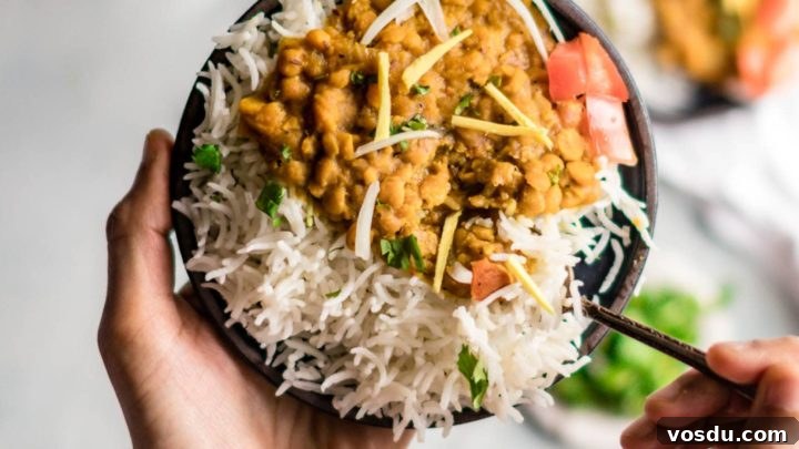 Holding a plate of chana dal with a spoon in it