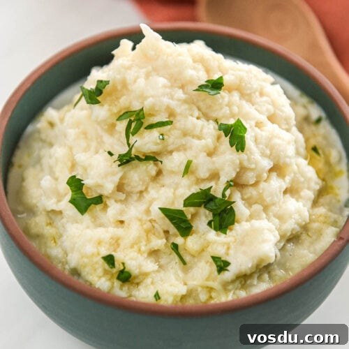 Slow-Cooker Whipped Cauliflower Recipe for Creamy Mash 12 mashed cauliflower in green bowl topped with fresh chopped parsley