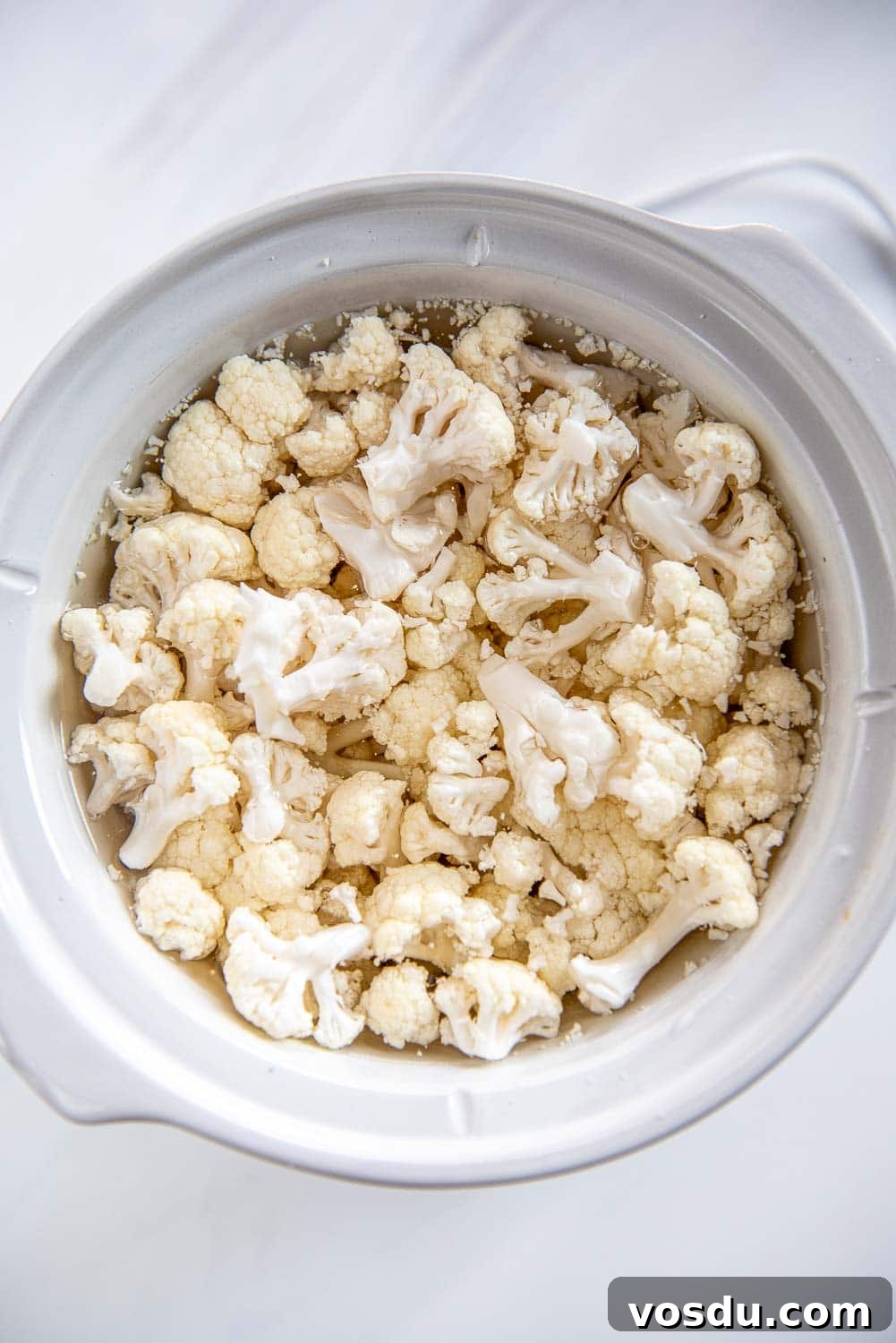 Slow-Cooker Whipped Cauliflower Recipe for Creamy Mash 7 white slow cooker filled with fresh chopped cauliflower and water