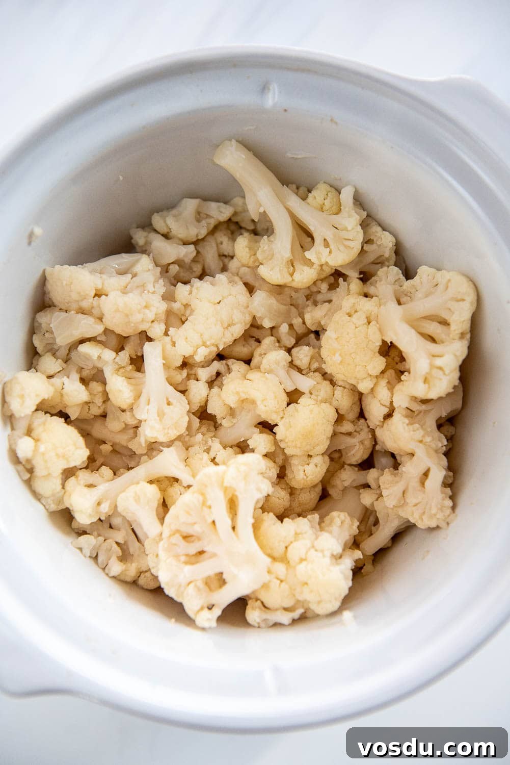 Slow-Cooker Whipped Cauliflower Recipe for Creamy Mash 8 slow cooker with cooked cauliflower pieces
