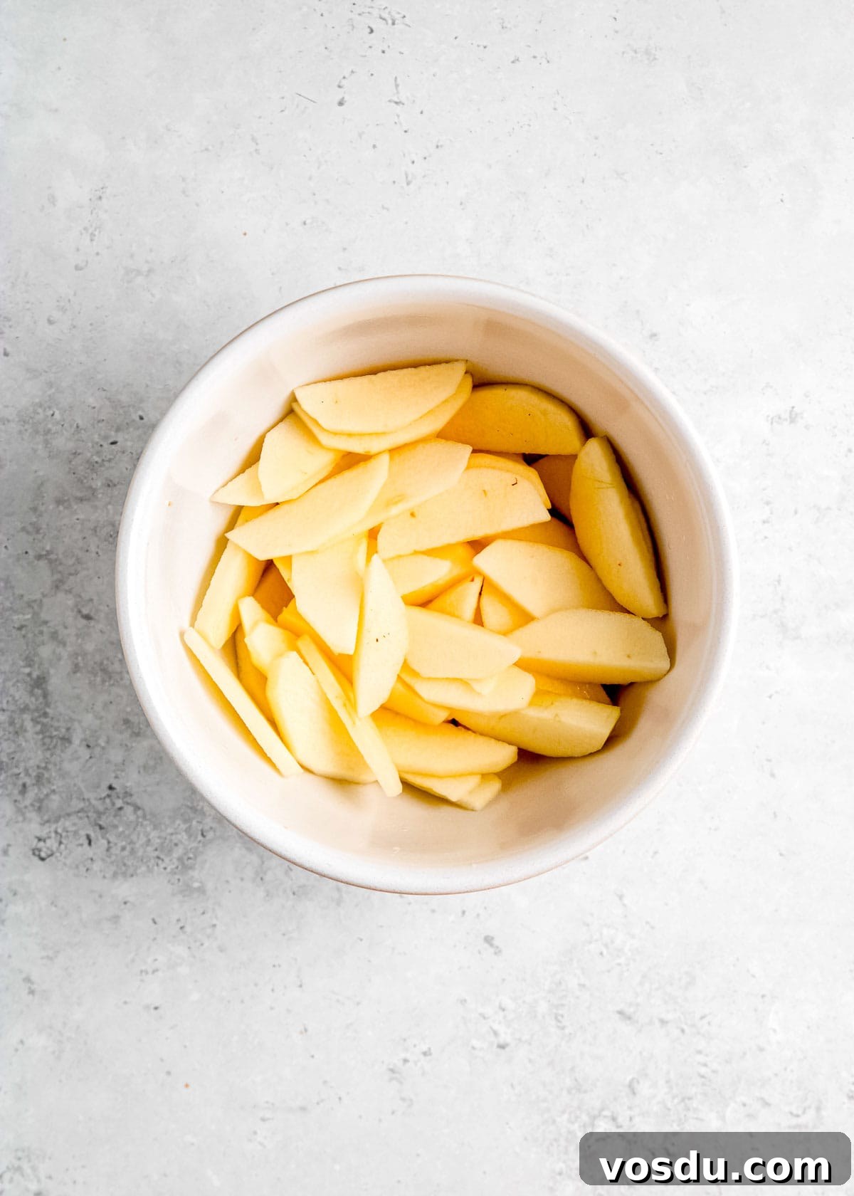 Crispy Cinnamon Air Fryer Apples Recipe 6 sliced apples and melted butter in a bowl