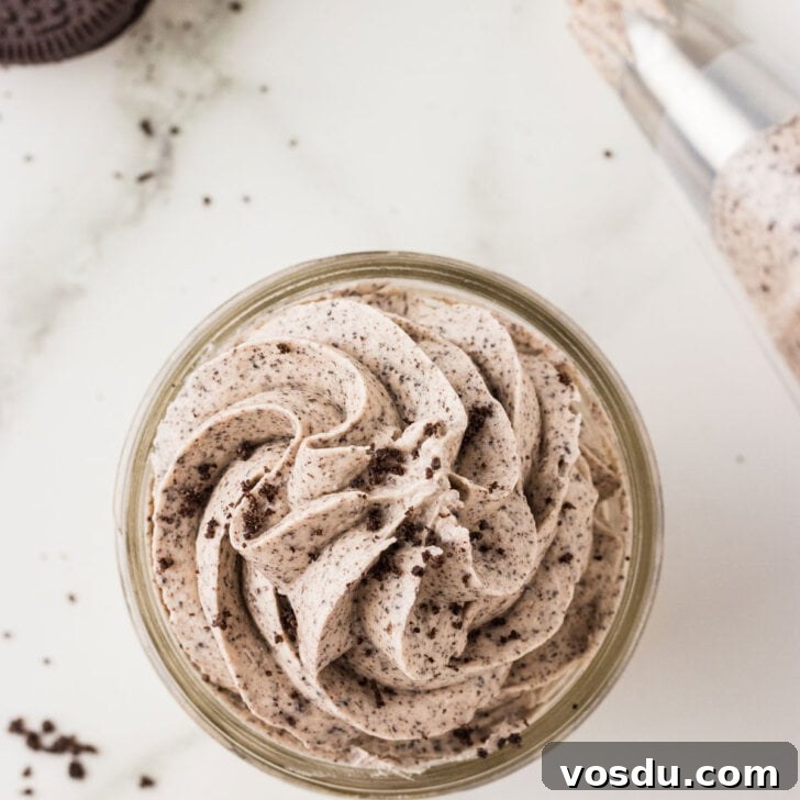 Cookies and Cream frosting piped into a small glass jar and topped with a few crushed gluten free Oreo crumbs
