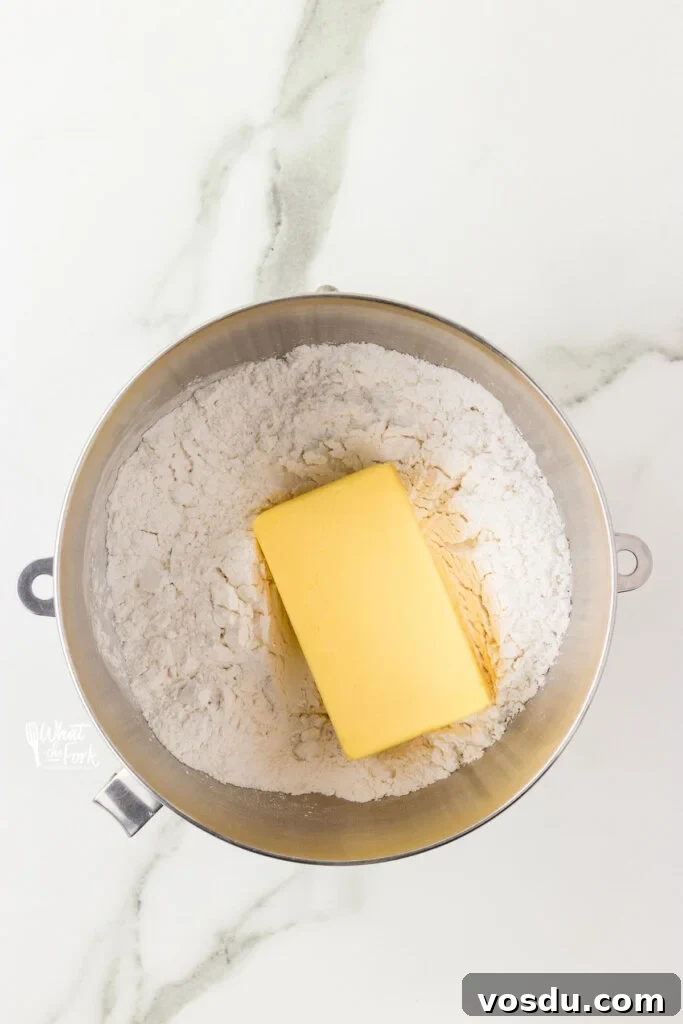 powdered sugar and a block of butter in a large silver bowl