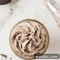 Cookies and Cream frosting piped into a small glass jar and topped with a few crushed gluten free Oreo crumbs
