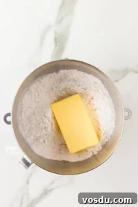 powdered sugar and a block of butter in a large silver bowl