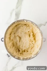 Vanilla buttercream frosting in a large silver bowl ready for Oreo cookie crumbs to be added to make Cookies and Cream frosting
