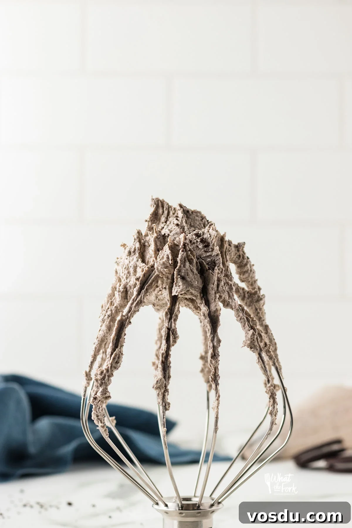 Cookies and Cream Frosting on a the tip of a Kitchenaid Whisk that's standing up on a counter