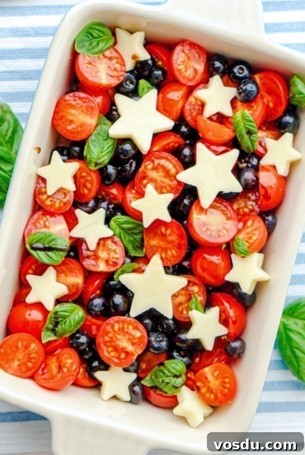 Blueberries, tomatoes, and mozzarella cheese shaped into stars, in a rectangle baking dish.