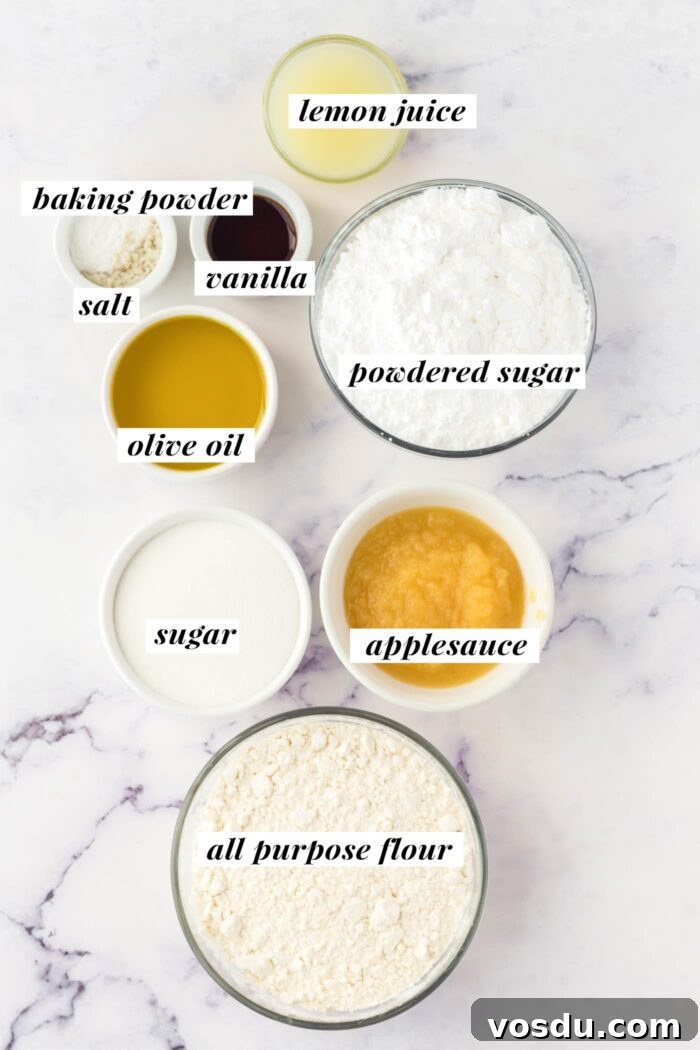The ingredients for a vegan olive oil cake recipe gathered in bowls and labelled with text. The complete ingredient list for this recipe can be found on the corresponding blog page.
