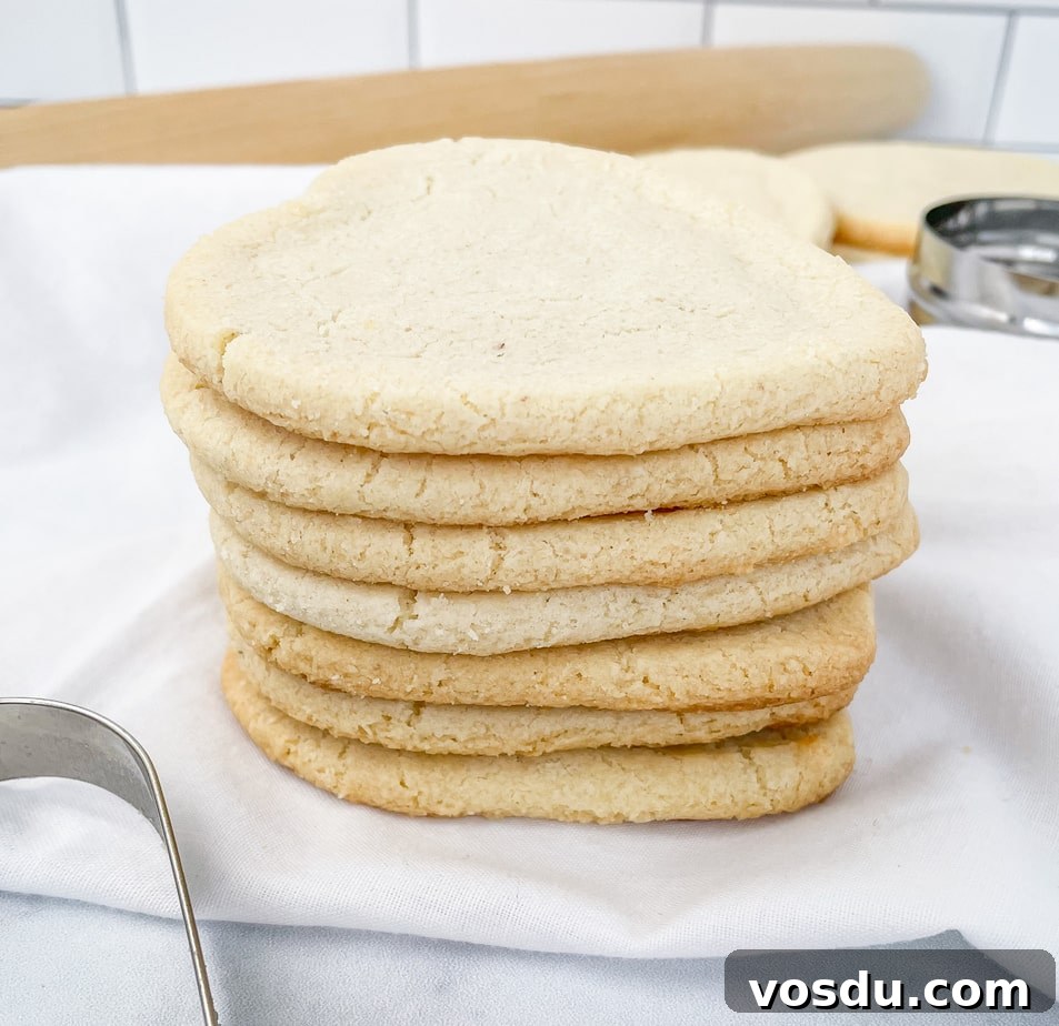 Almond Flour Shortbread Cookies Recipe — Buttery Gluten-Free Treat 9 Closeup of a stack of heart shaped almond flour cookies sitting on a white napkin. A cookie cutter and rolling pin in the background