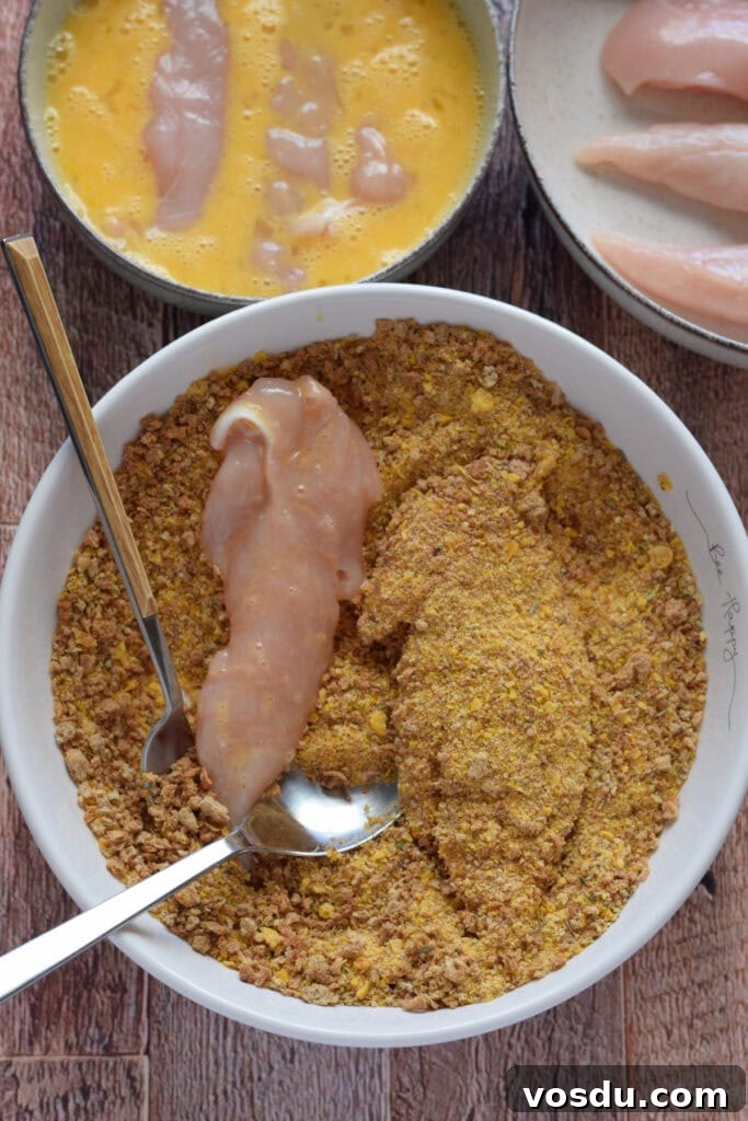 Cajun Chicken Tenders Recipe: Crispy Spicy Oven-Baked Option 7 Dipping chicken tenders in bread crumbs.