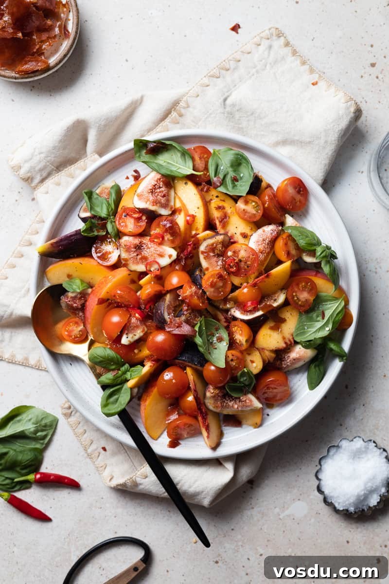 Peach and Prosciutto Salad with Burrata and Arugula 2 Peach and Prosciutto Salad on a white platter with a black and gold serving spoon.