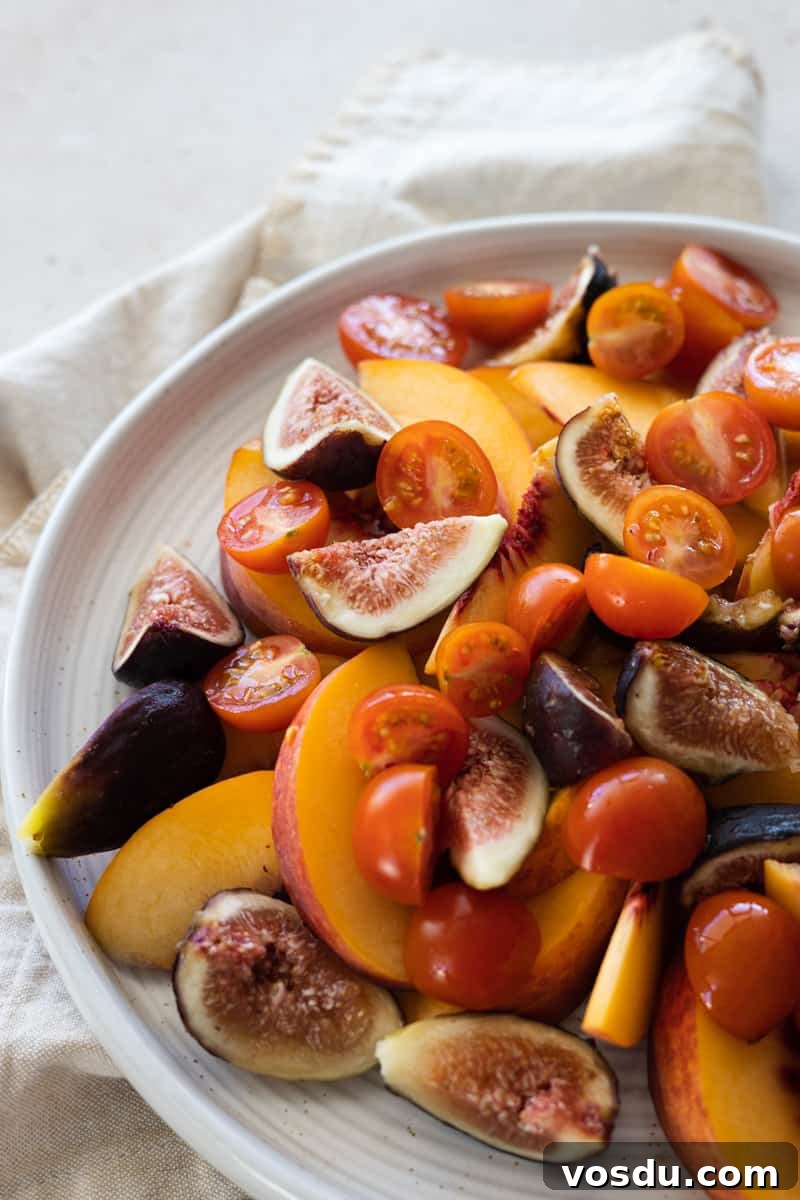 Peach and Prosciutto Salad with Burrata and Arugula 6 Sliced peaches, figs and cherry tomatoes on a white platter.