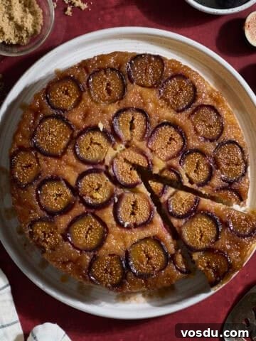 Sourdough Fig Cake on a white platter with a slice cut out.