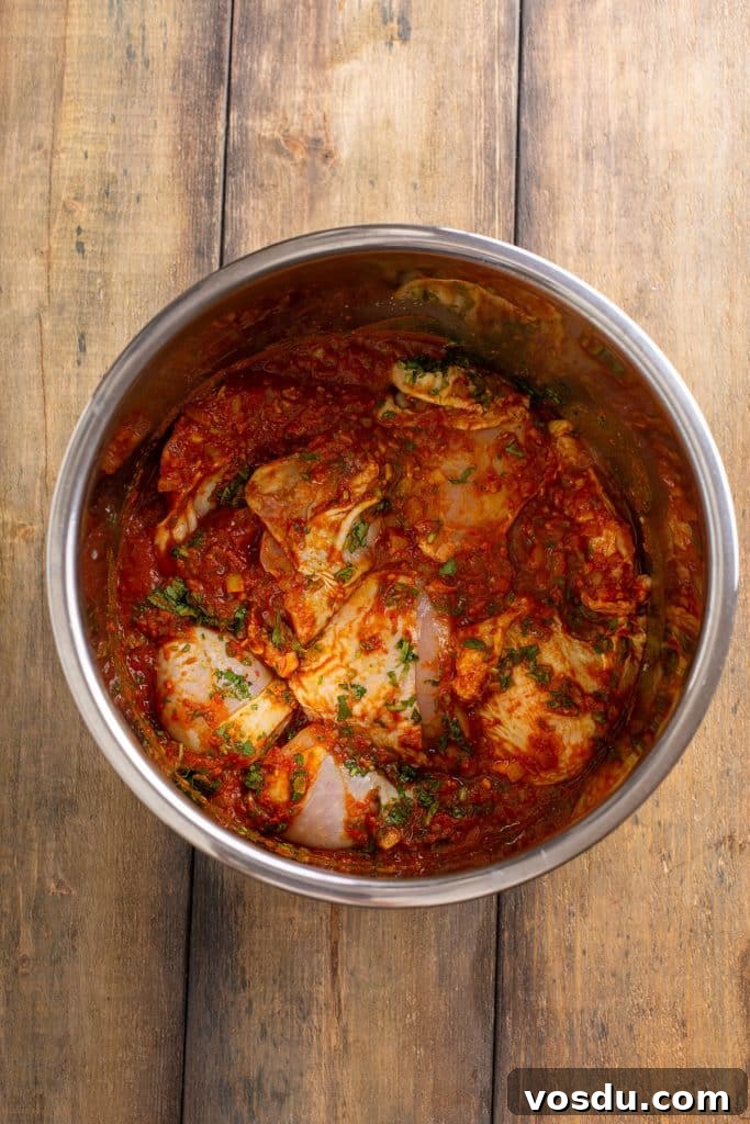 raw chicken and sauce in an instant pot