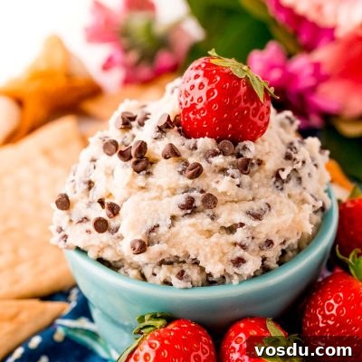 Mascarpone Cannoli Dip Recipe: Creamy Dessert Dip for Parties 7 Close up photo of a teal bowl filled with cannoli dip surrounded by crackers and strawberries.