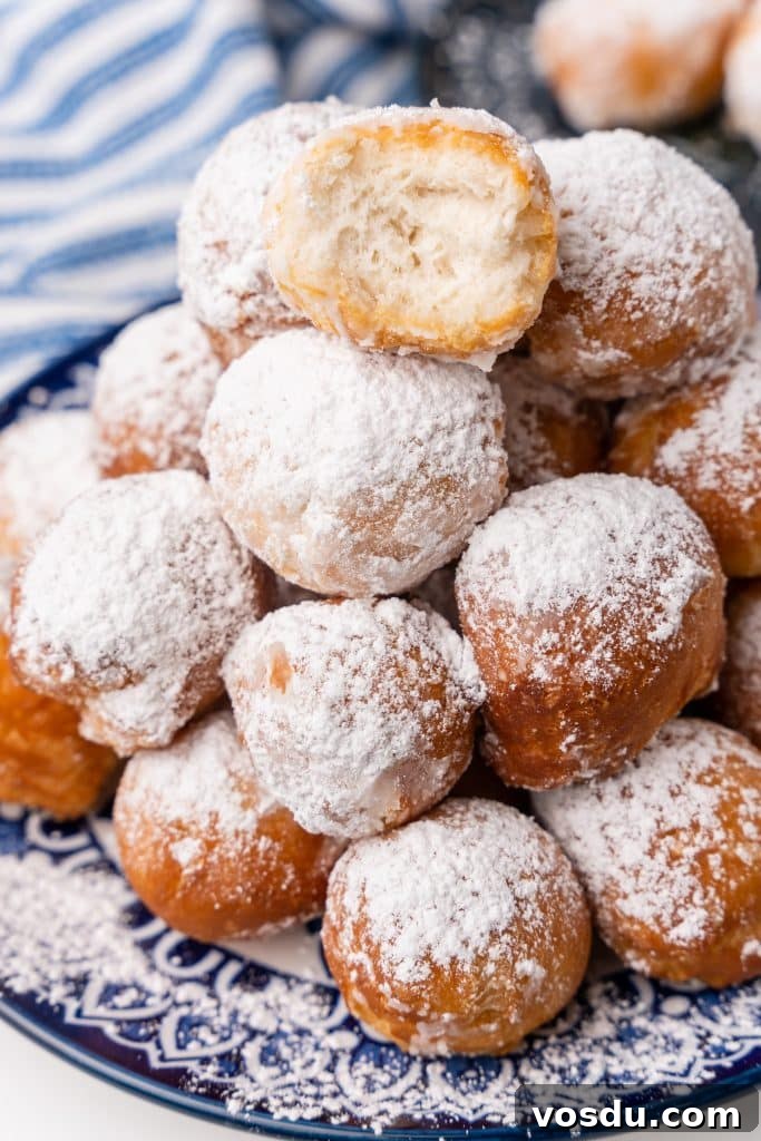 canned biscuit beignets piled on a blue and white plate