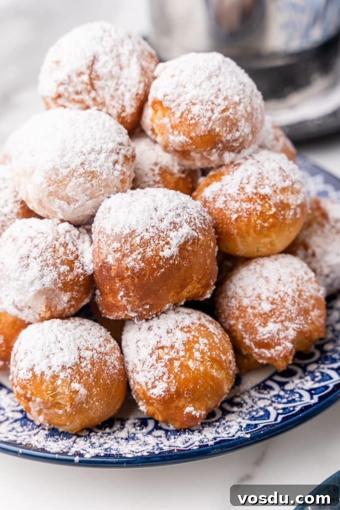 canned biscuit beignets piled on a blue and white plate