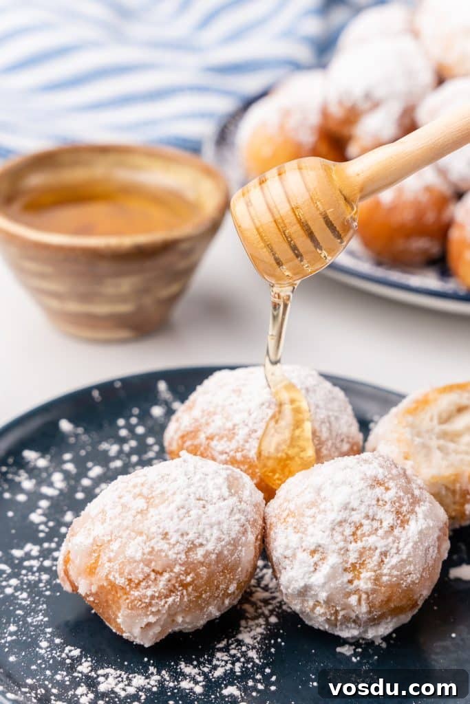 honey being drizzle over a plate of easy homemade beignets