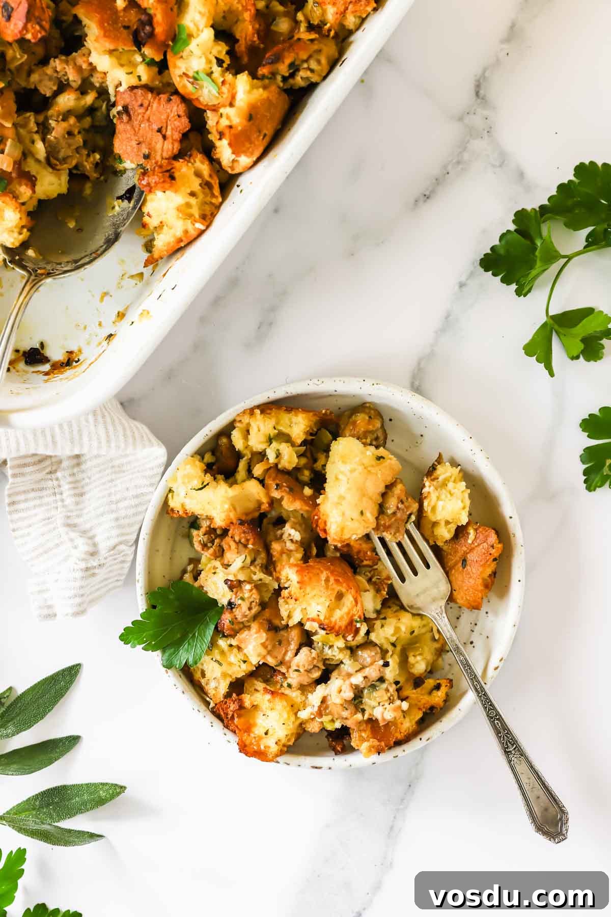 Savory Sausage Stuffing Recipe for Holiday Dinners 9 A bowl of sausage stuffing with a fork sticking out.