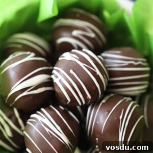 3-Ingredient Oreo Truffles — Quick No-Bake Dessert 7 bowl of chocolate Oreo Truffles drizzled with white chocolate with green tissue paper