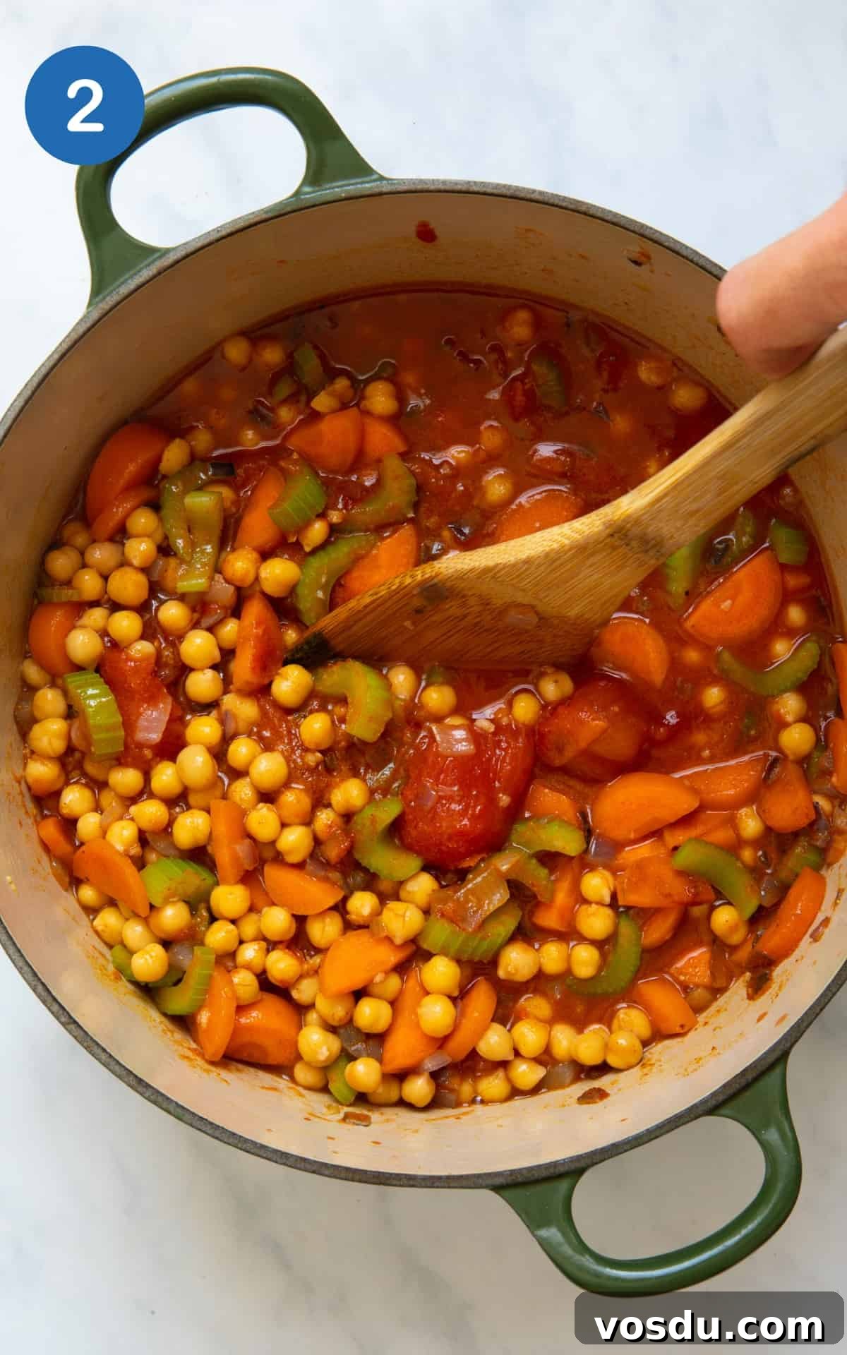 15-Minute Chickpea Stew Recipe for Quick Weeknight Dinners 5 All ingredient to make chickpea stew in large pot displayed on white background.