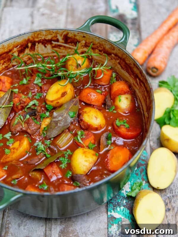 15-Minute Chickpea Stew Recipe for Quick Weeknight Dinners 8 hearty potato stew cooked in a green pot, served on a wooden background.