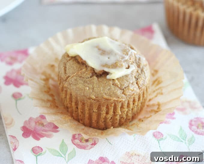 Moist Carrot Muffins with Cinnamon and Maple Glaze 2 Muffin on a flower napkin with butter on top.