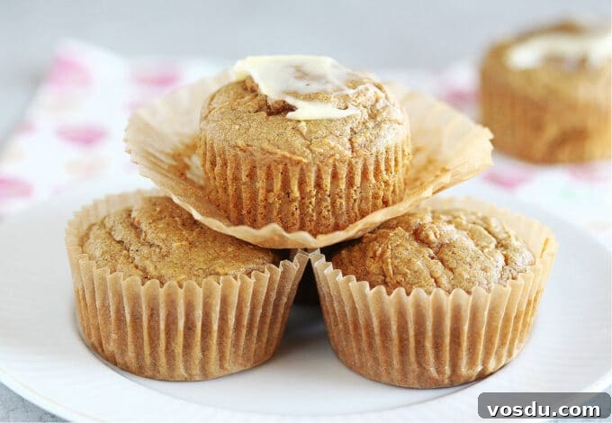 Moist Carrot Muffins with Cinnamon and Maple Glaze 10 Stack of three muffin on a white plate.