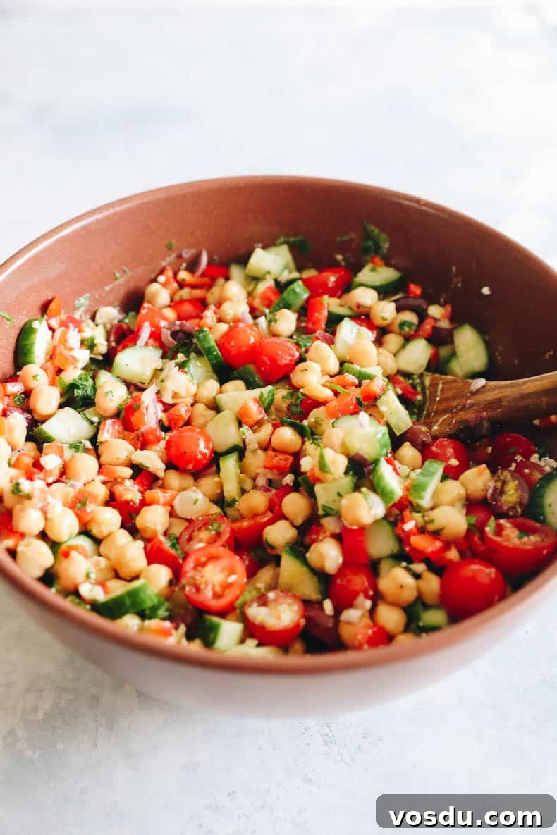 Mediterranean Chickpea Salad with Lemon-Herb Vinaigrette 4 mediterranean salad recipe in a big brown bowl mixed together.