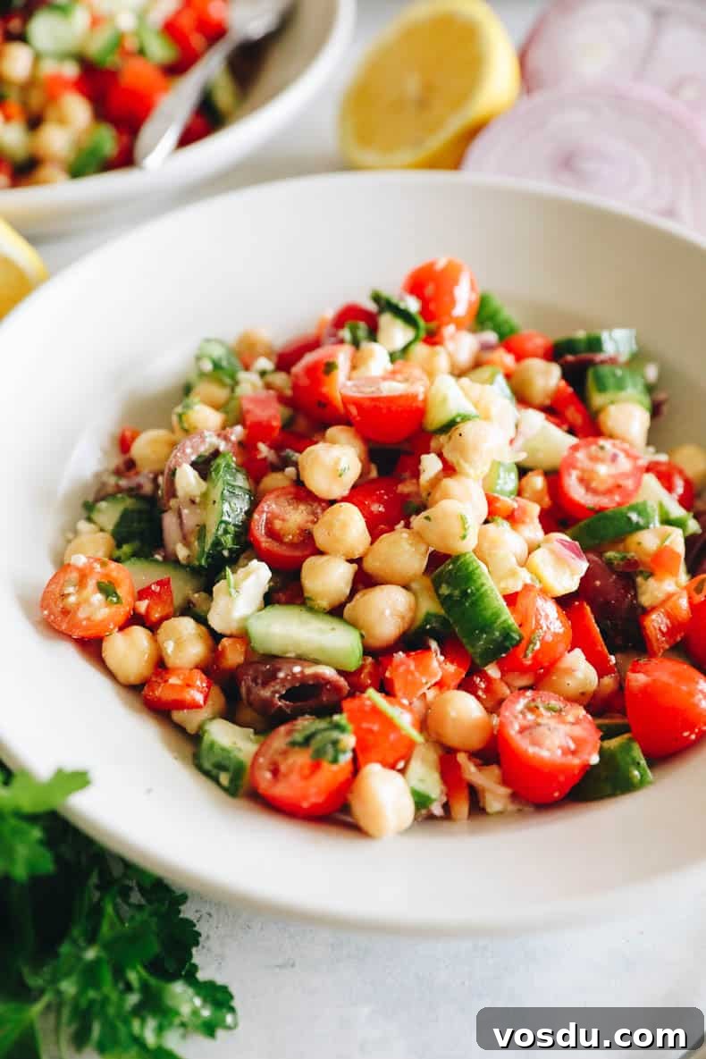 Mediterranean Chickpea Salad with Lemon-Herb Vinaigrette 5 upclose image of mediterranean chickpea salad in a white shallow bowl.