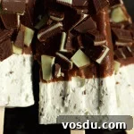 Mint Chocolate Cheesecake Popsicle Recipe: Creamy No-Bake Dessert 5 Close up of a mint chocolate cheesecake popsicle. The top half is coated in chocolate and chopped andes mints.