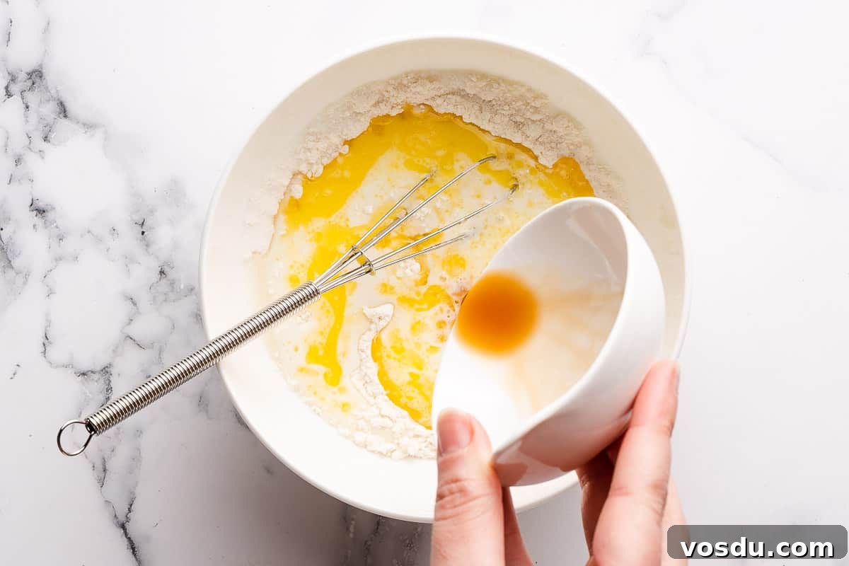 3-Minute Oreo Mug Cake Recipe You Can Make in a Microwave 5 hand pouring vanilla extract into cake batter