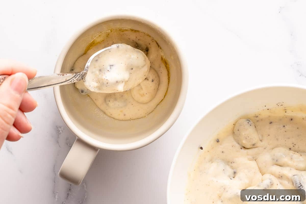 3-Minute Oreo Mug Cake Recipe You Can Make in a Microwave 8 hand spooning Oreo batter into mug