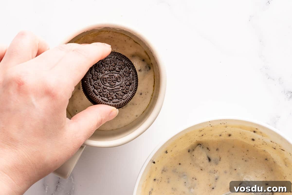 3-Minute Oreo Mug Cake Recipe You Can Make in a Microwave 9 Oreo being placed on top of batter in mug