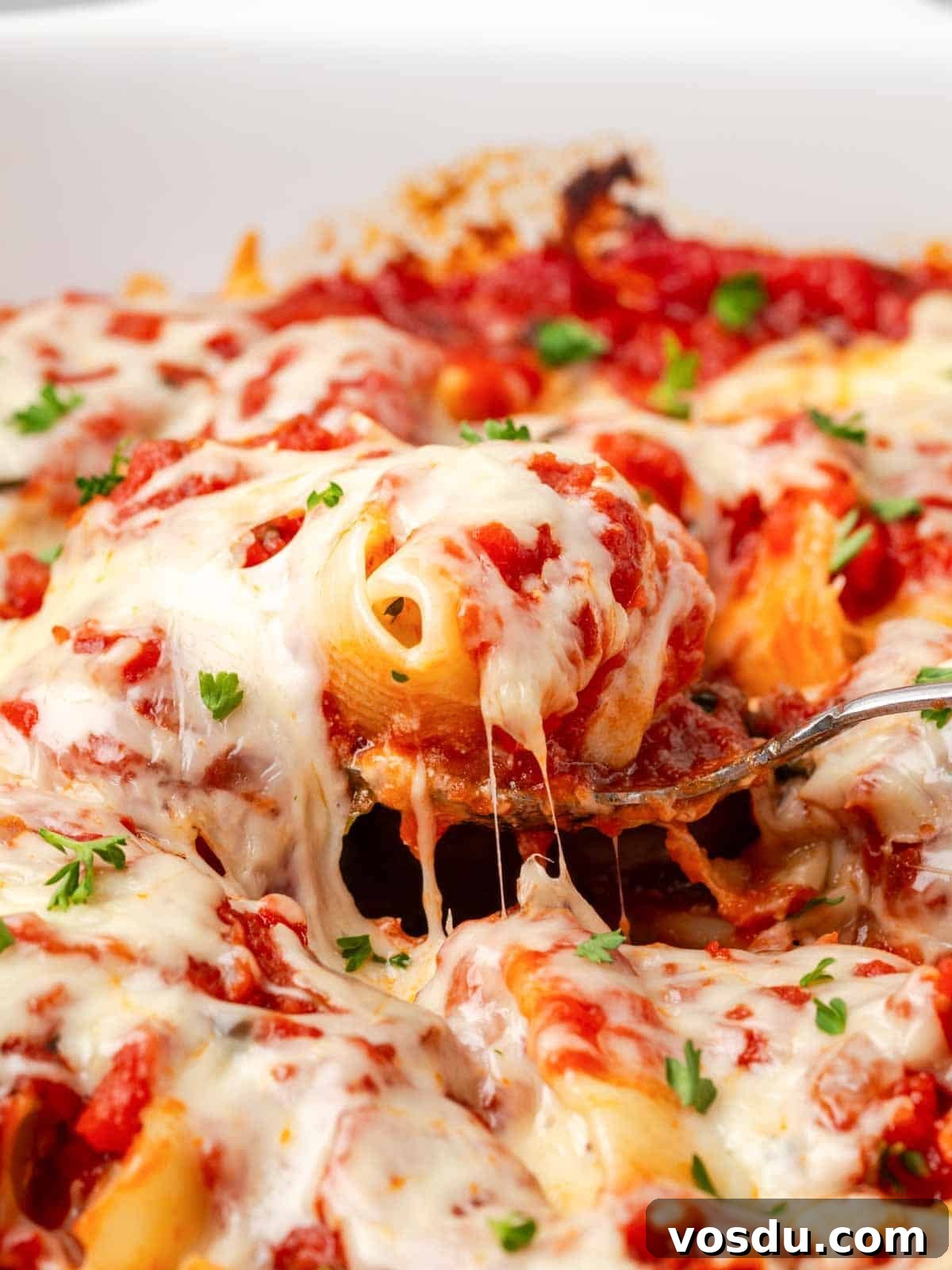 Cheesy Baked Stuffed Shells with Italian Meat Filling 14 melted cheese pulling around stuffed shell on spoon.