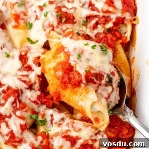 Cheesy Baked Stuffed Shells with Italian Meat Filling 15 stuffed shell on spoon in dish.