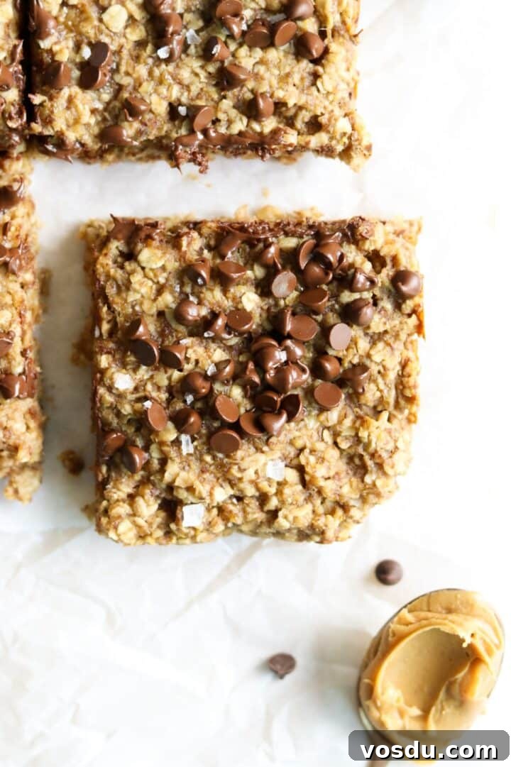 Peanut butter banana oatmeal bar square with chocolate chips on a piece of white parchment paper