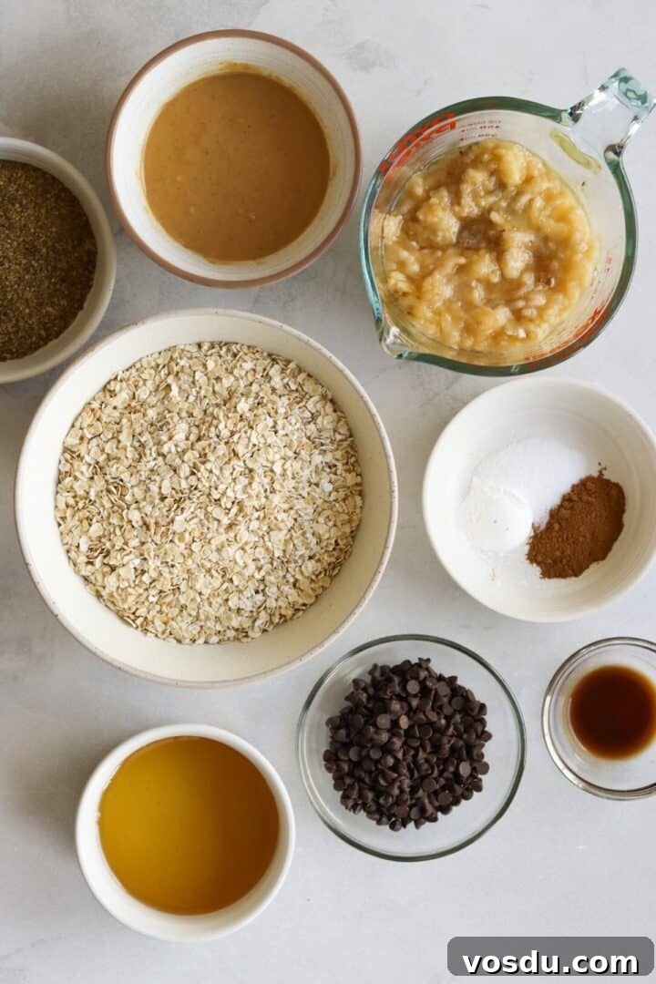 Ingredients for banana peanut butter oat bars displayed in small bowls on a marble kitchen counter