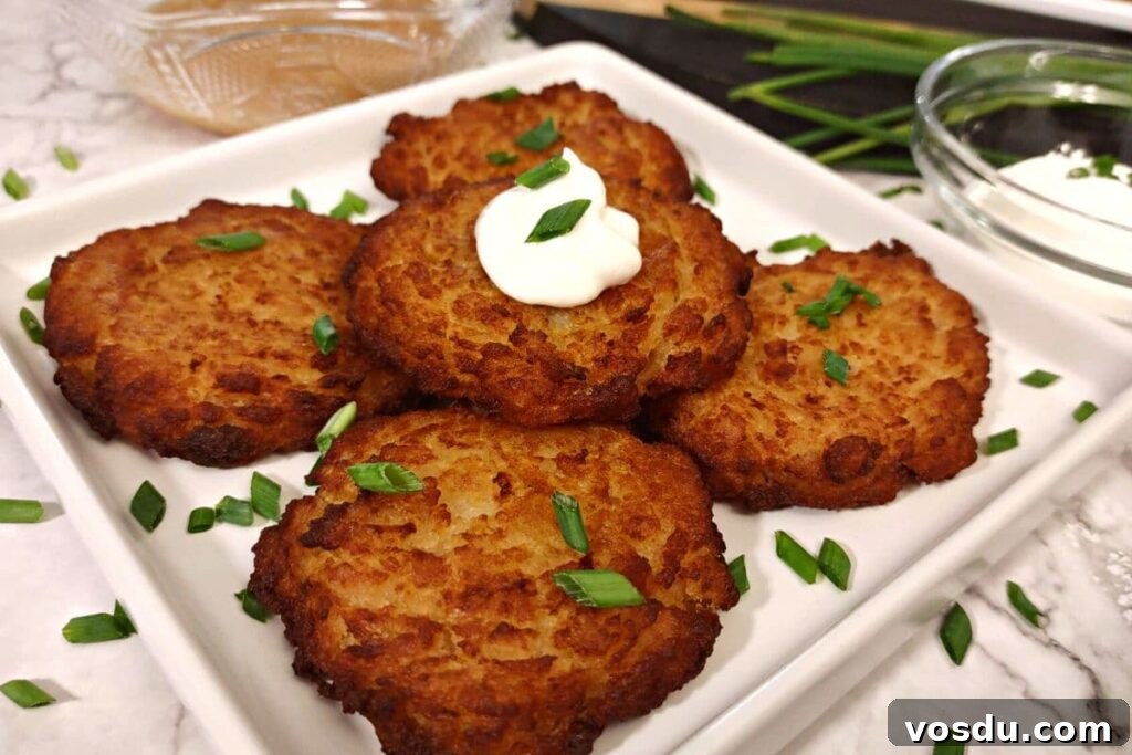 Air Fryer Trader Joe’s Frozen Latkes (Crispy Potato Pancakes) 7 trader joe's potato latkes on a square plate with sour cream on top