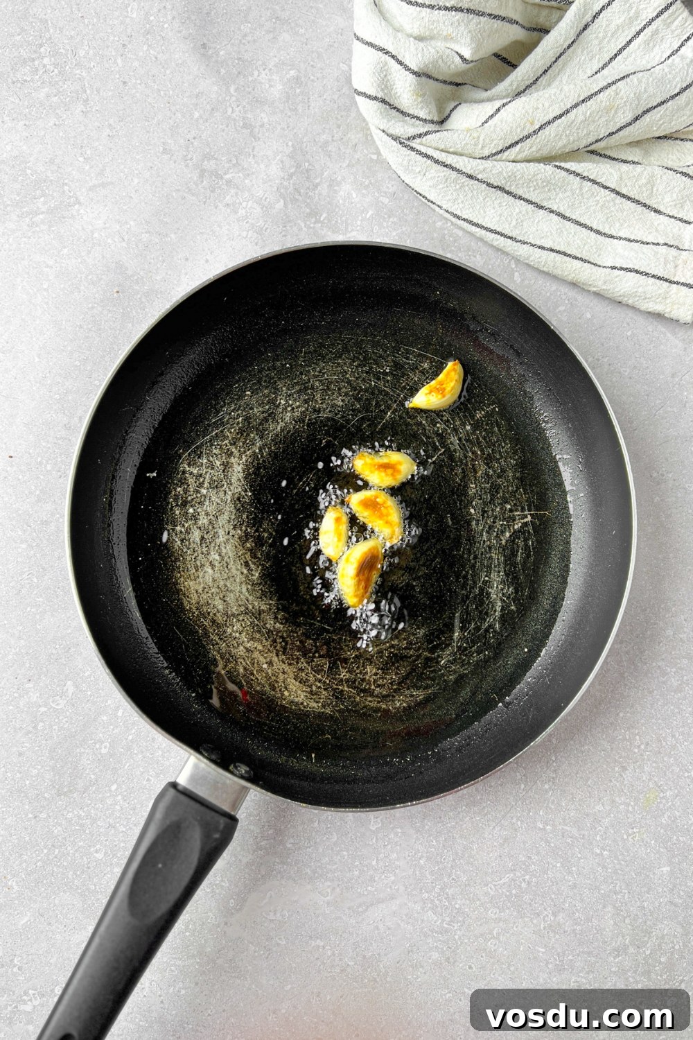 Garlic frying in a pan in oil.
