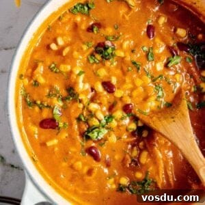 Creamy Chicken Enchilada Soup Recipe for Cozy Weeknight Dinners 10 A pot of soup with corn, beans and cheese.