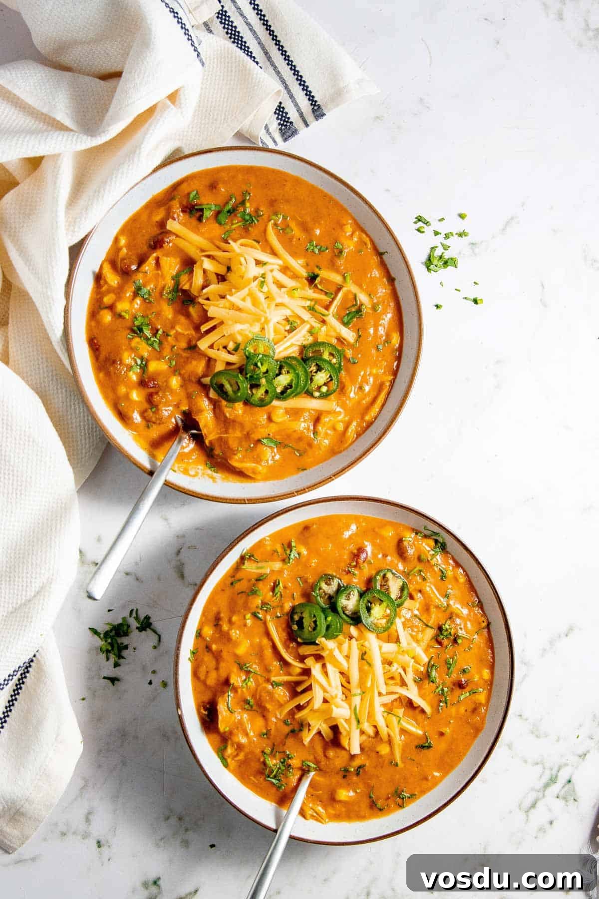 Creamy Chicken Enchilada Soup Recipe for Cozy Weeknight Dinners 9 Two bowls of leftover chicken soup with cheese and parsley.