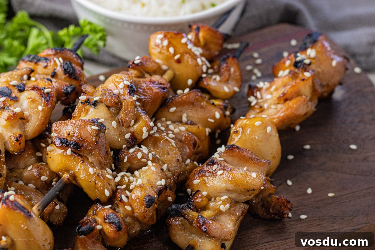 Sticky Teriyaki Chicken Skewers with Sesame and Green Onion 4 grilled chicken on wooden skewers topped with sesame seeds