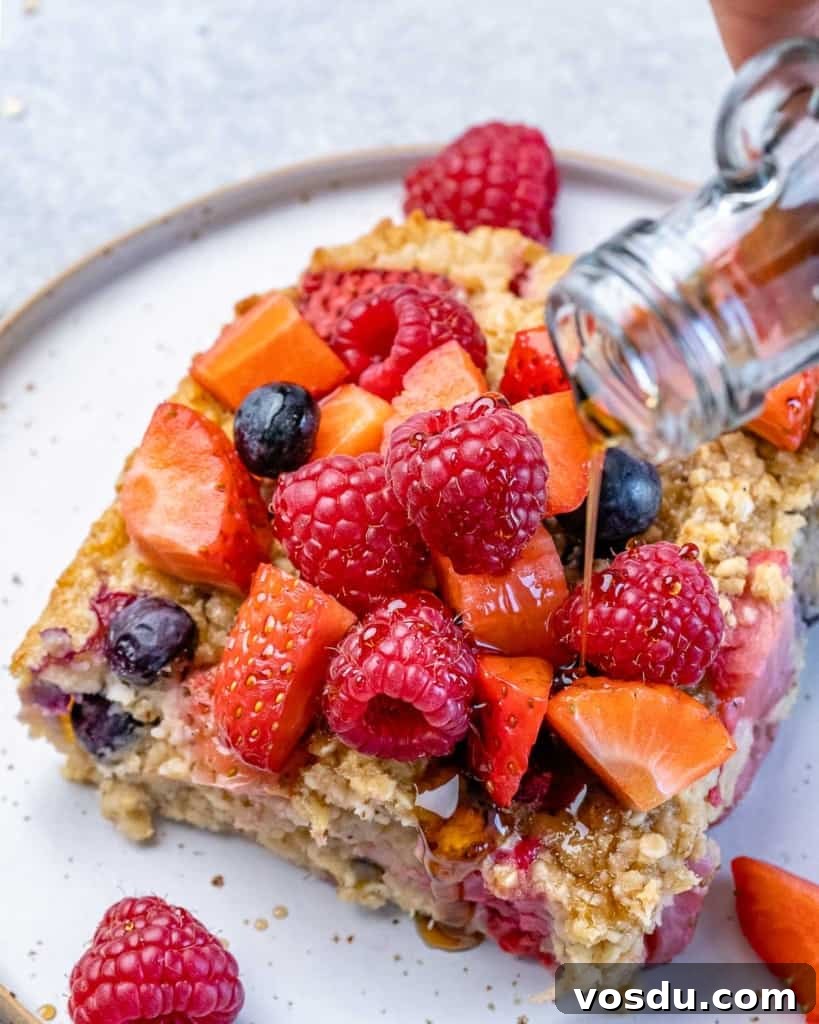 maple syrup being poured over slice of baked oatmeal 